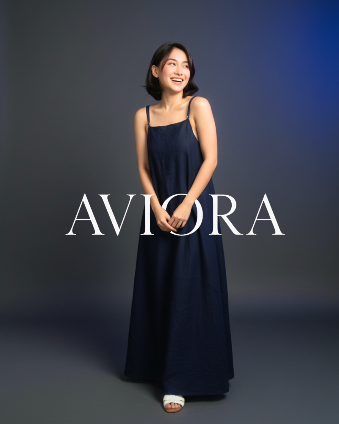 Woman wearing a navy blue dress with 'AVIORA' branding on a dark background